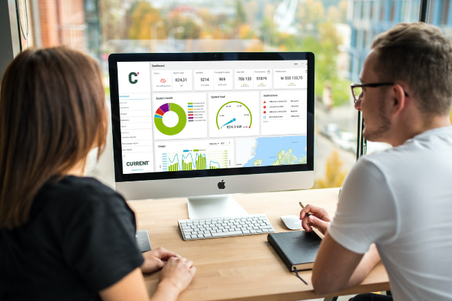 one woman and one man, casually clothed, are looking at the administration system of Current's Smartcharge solution